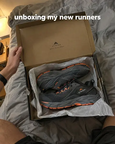 Phone shot unboxing new running shoes on a bed